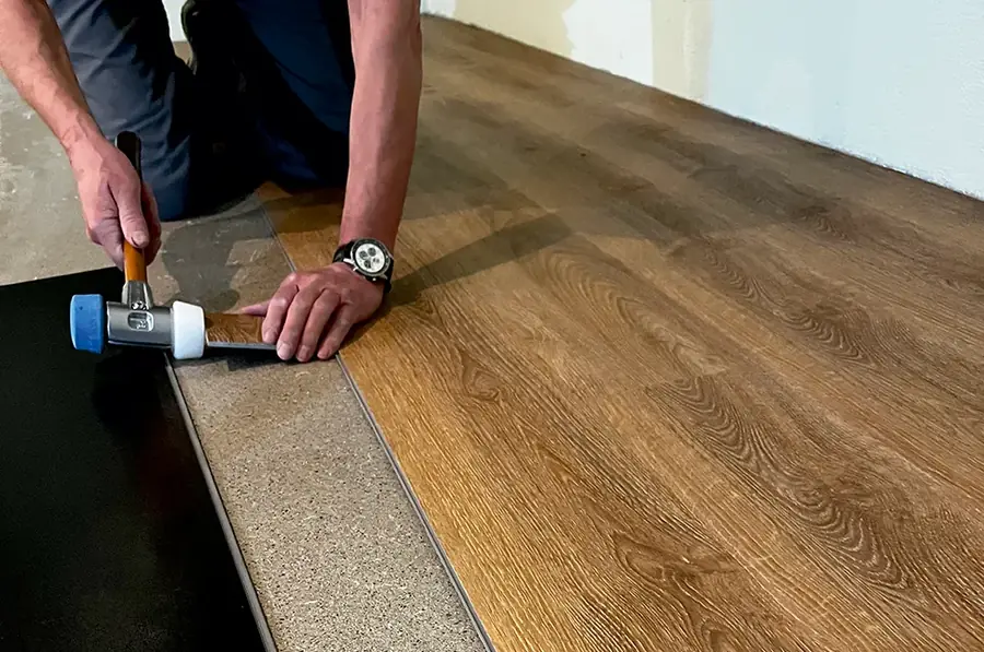 Ein Bodenleger von Wörner verlegt Dielen in Holzoptik